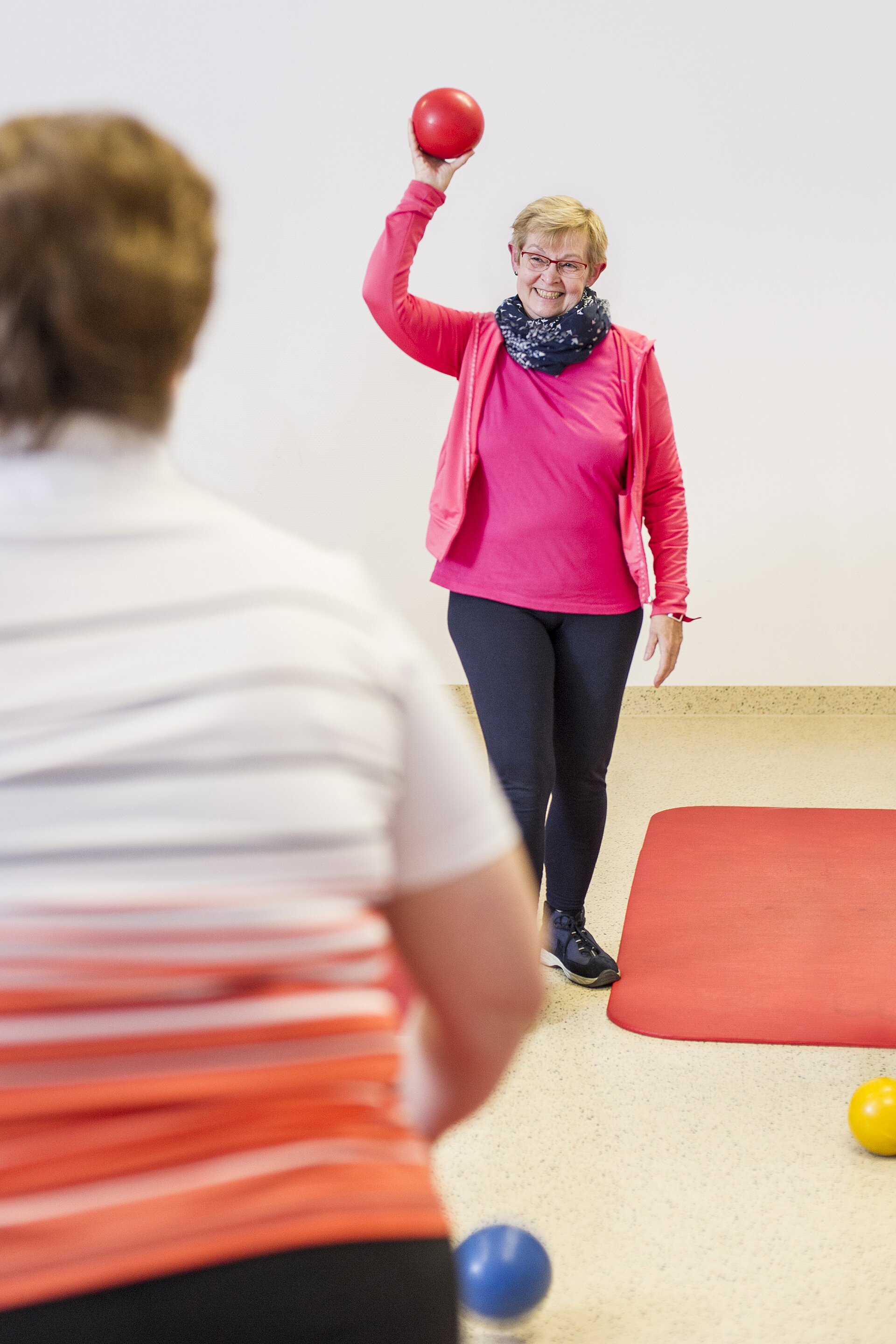 Zwei Frauen mit rotem Ball beim Funktionstraining