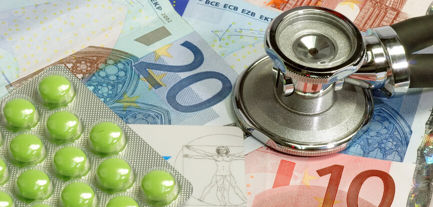 Symbolbild Krankenversicherung: Geldscheine, Stethoskop, Tablettenpackung, Krankenversichertenkarte