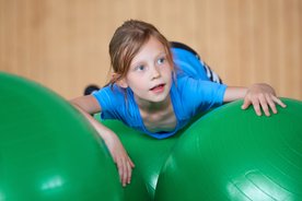 Mädchen auf grünen Gymnastikbällen