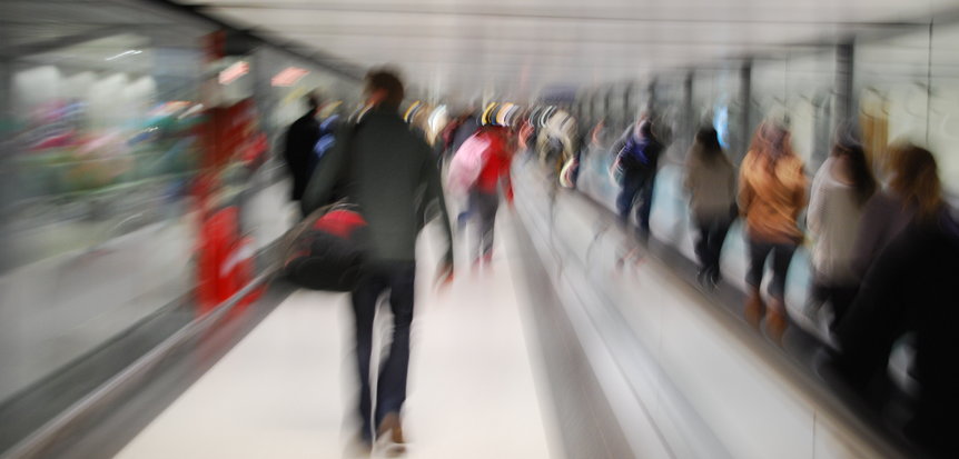 Symbolbild Mobilität: Langzeitbelichtete Aufnahme von Menschen in einem Durchgang