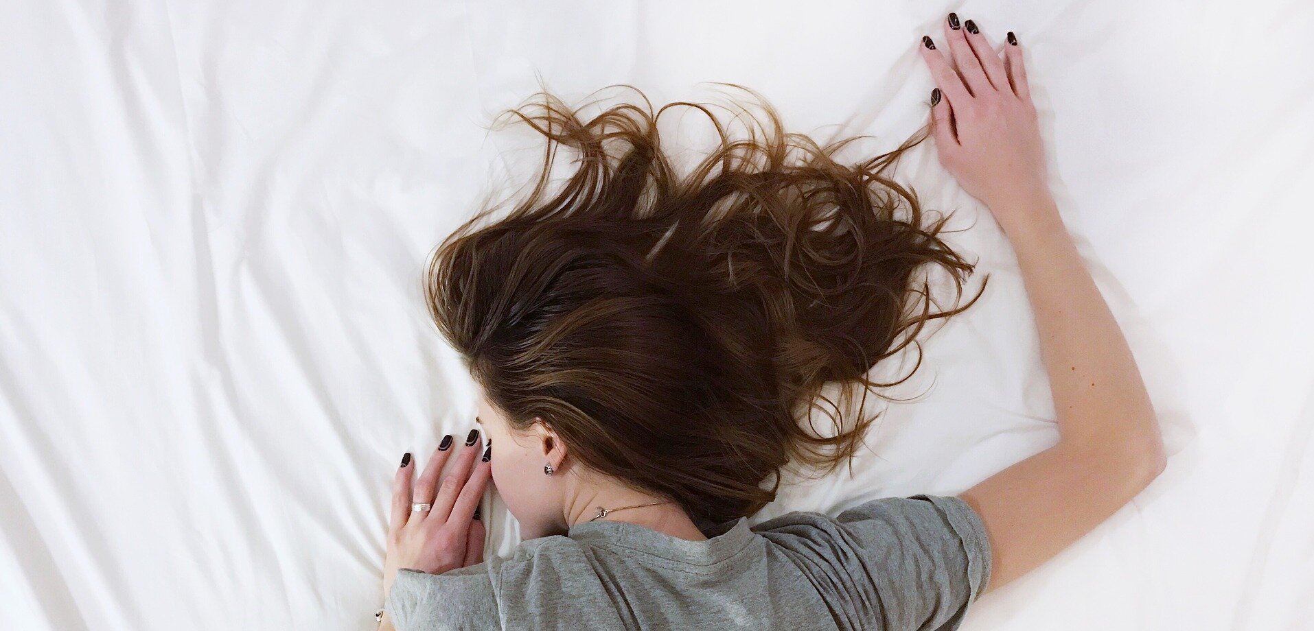 Symbolbild Schlaf: eine Frau liegt auf dem Bauch