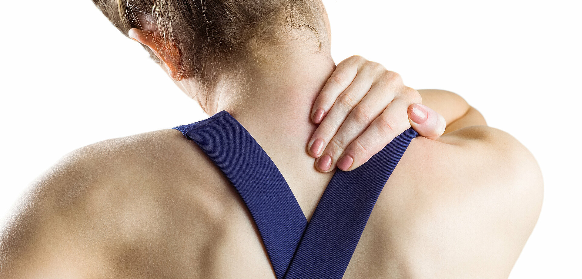 Symbolbild Muskelschmerzen: Frau mit Sportkleidung greift sich an den Nacken
