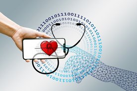 Symbolillustration Digitalisierung Gesundheitswesen: Eine Hand hält ein Smartphone, auf dem ein Herz zu sehen ist. Im Hintergrund ist ein Stethoskop abgebildet.