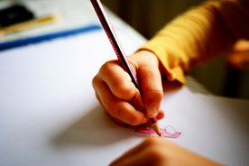 Ein Kind malt mit einem Buntstift.