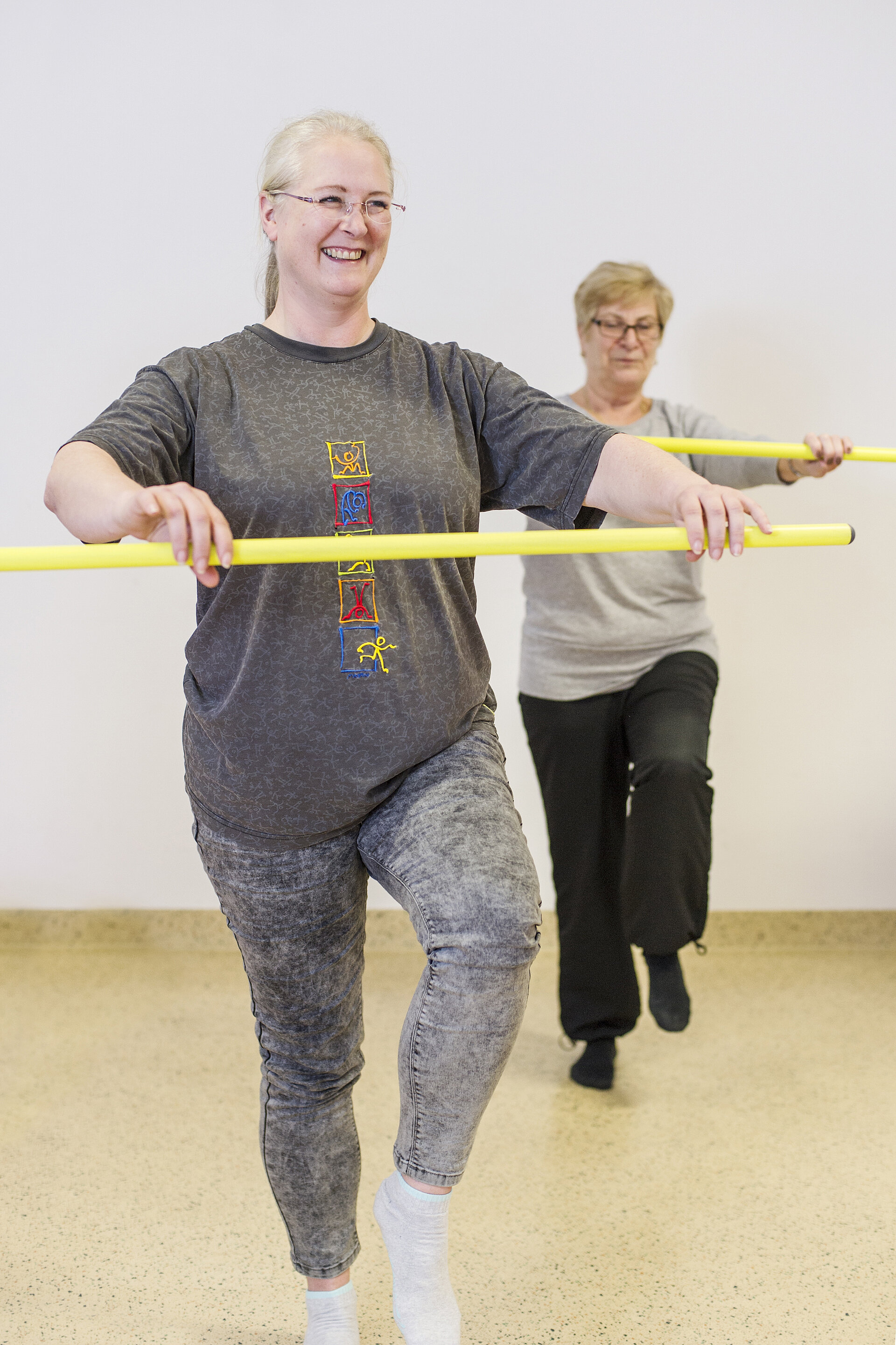 Zwei Frauen mit gelbem Stab beim Funktionstraining